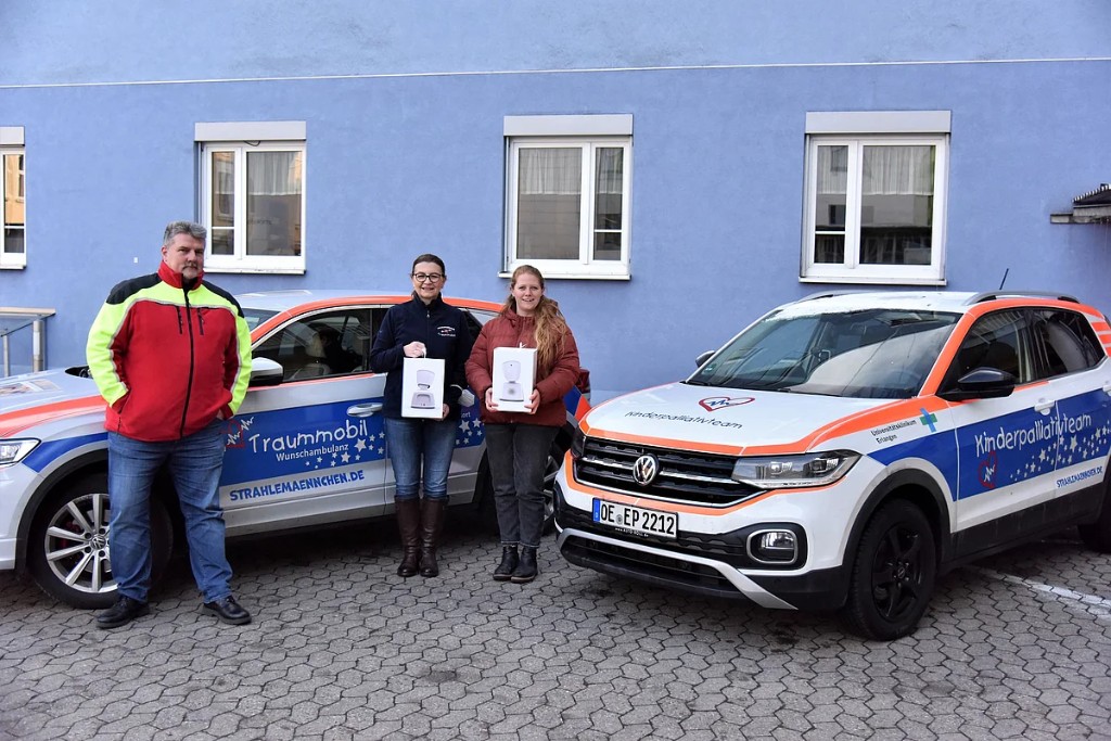 Fahrzeugübergabe vor dem Traummobil und einem Fahrzeug des Kinderpalliativteams